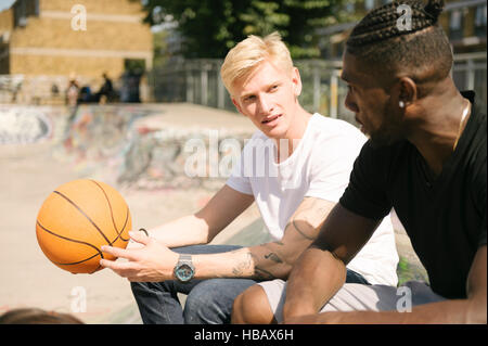 Zwei junge männliche Basketball-Spieler im Chat in Stadt skatepark Stockfoto