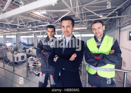 Team-Manager und zwei Arbeiter in CNC-Fabrik Stockfoto