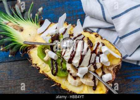 Weihnachten festlich Ananas halbieren mit einer Kugel Eis mit Chia, Kiwi, Kokosnuss, Cashew. Perfekt für die Dessert-Diät oder einfach eine gesunde mea Stockfoto