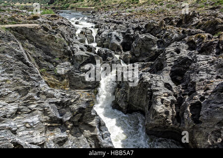 Wasserfall fließt zwischen den Lavasteinen Stockfoto