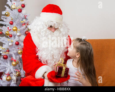 Santa Claus gibt ein Geschenk ein fünfjährigen Mädchens Stockfoto