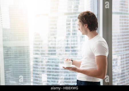 Schönen jungen Mann in der Nähe von voller Länge Fenster Stockfoto