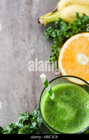 Smoothie mit Grünkohl, Banane und Orange auf hölzernen Hintergrund Stockfoto