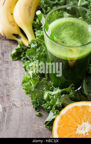 Smoothie mit Grünkohl, Banane und Orange auf hölzernen Hintergrund Stockfoto