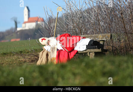 Offingen, Deutschland. 6. Dezember 2016.  Ein Mann verkleidet als Weihnachtsmann nimmt ein Nickerchen auf einer Parkbank in Offingen, Deutschland, 6. Dezember 2016. Foto: Thomas Warnack/Dpa/Alamy Live News Stockfoto