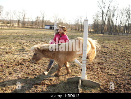 Junges Mädchen im Freien, Pony führen über Bar Stockfoto