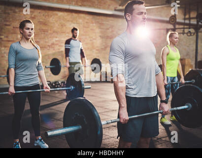 Junge Menschen Fit anheben Barbells konzentriert, in einer Turnhalle Stockfoto