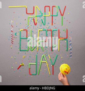 Kreative Stillleben Foto von alles Gute zum Geburtstag Schild made of cocktail Strohhalme mit Konfetti und Serpentin auf grauem Hintergrund. Stockfoto