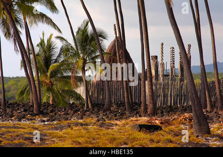 Hale o Keawe Heaiu, strohgedeckten Königliche Mausoleum und Ki'i Wächter, Pu'uhonua o Honaunau, Ort der Zuflucht, Pu'uhonua o Honaunau National Historical Park, Stockfoto