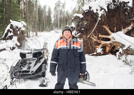 Professionelle Holzfäller halten Hand sah. Winter Kleidung Schutz mit Kettensäge. umgestürzte Bäume zu reinigen. Stockfoto