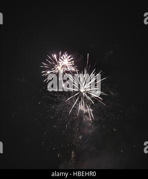 Glänzend natürliche Feuerwerk auf dunklen schwarzen Himmelshintergrund mit ein wenig Rauch Stockfoto