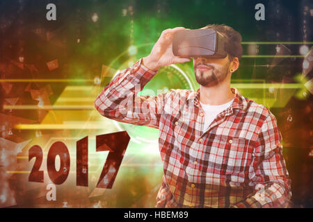 Zusammengesetztes Bild von legerer Mann Mann, hält virtuelle Brille auf weißem Hintergrund Stockfoto