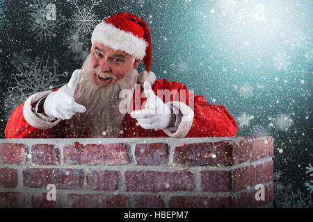 Zusammengesetztes Bild des Porträts von happy Santa Claus die Handbewegung über Mauer Stockfoto