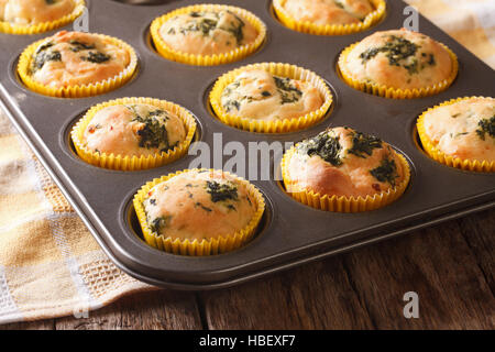 Muffins mit frischem Spinat und Feta-Käse hautnah in Auflaufform auf den Tisch. Horizontale Stockfoto