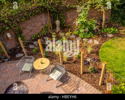Moderner Garten mit kreisförmigen Rasen und Block gepflasterte Terrasse von oben gesehen Stockfoto
