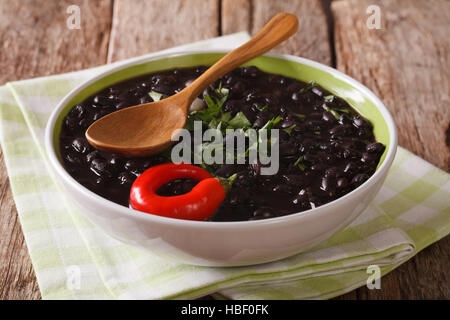 Vegetarische schwarze Bohnensuppe hautnah in einer Schüssel auf dem Tisch. horizontale Stockfoto