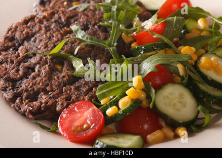 Schwarze Bohnen-Burger mit Salat aus frischem Gemüse Makro auf einem Teller. horizontale Stockfoto