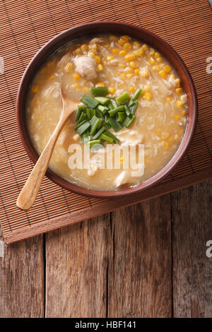 Chinesisches Essen: Mais-Suppe mit Hühnerfleisch und Zwiebeln in einer Schüssel Nahaufnahme. vertikale Ansicht von oben Stockfoto