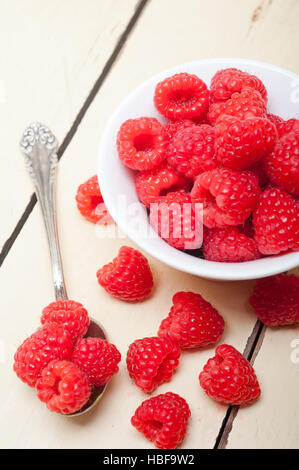 Reihe von frischen Himbeeren in einer Schüssel und weiße Tabelle Stockfoto