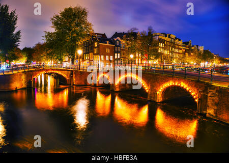 Blick auf die Stadt Amsterdam mit Kanälen und Brücken in der Nacht Stockfoto