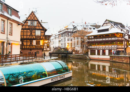 Ausflugsschiff mit Touristen entlang dem Fluss Ill Petite France zur Weihnachtszeit, Straßburg, Elsass, Bas-Rhin-Frankreich Stockfoto