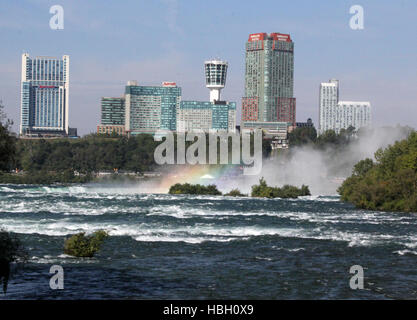 Niagara River an den Niagarafällen mit Stadtbild von Ontario im Hintergrund einschließlich Skylon Tower mit einem steigenden Regenbogen-Nebel. Stockfoto