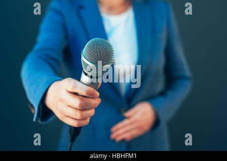 Elegante Journalistin Durchführung von Business-Interview oder Pressekonferenz, mit Mikrofon hand Stockfoto