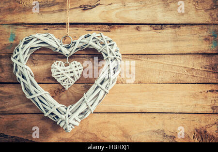 Zwei rustikale dekorative Holzherzen Vintage Holz-Hintergrund mit Raum hängen. Stockfoto