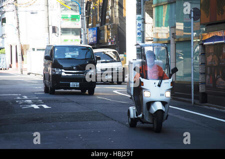 Japaner fahren Auto und fahren Motorrad unterwegs in kleinen Gasse im Stadtteil Shinjuku am 20. Oktober 2016 in Tokio, Japan Stockfoto