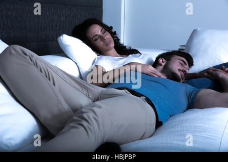 Junges Paar schläft auf dem Sofa in der Nacht Stockfoto