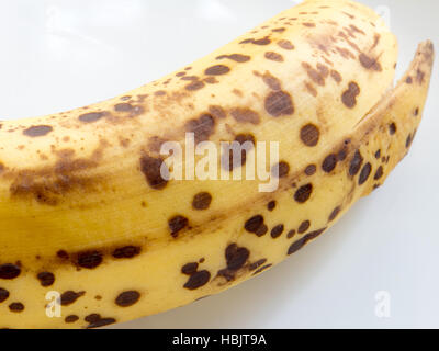 Gut reife Banane mit schwarzen Flecken auf weißem Hintergrund isoliert Stockfoto