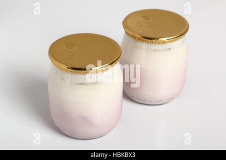 Joghurt in kleinen Glas mit Aluminium Folie Dichtungskappe. Isoliert auf weißem Hintergrund. Stockfoto