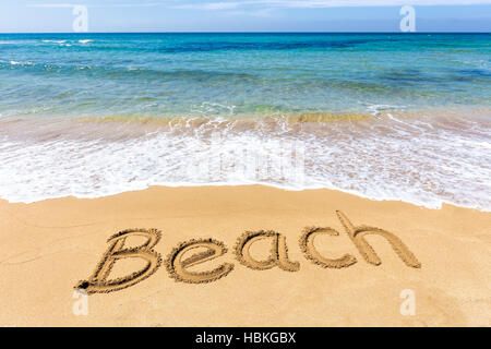 Wort geschrieben in Sand am griechischen Meer Strand Stockfoto