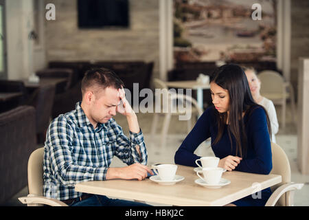 Junges Paar in einem Café streiten. Sie hat genug, Freund entschuldigen. Probleme in Beziehungen. Stockfoto