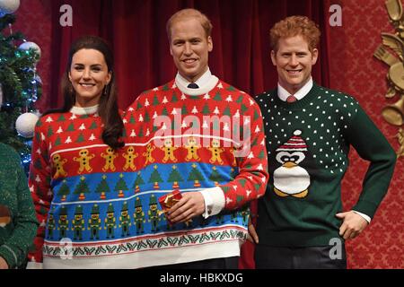 Wachs Figuren von Mitgliedern der königlichen Familie, von links, die Herzogin von Cambridge, der Duke of Cambridge und Prinz Harry, tragen ihre Weihnachts-Jumper in Madame Tussauds London, zur Sensibilisierung für Save the Children. Stockfoto