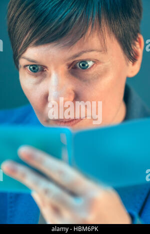 Schöne Geschäftsfrau Überprüfung Frisur in Taschenspiegel vor wichtigen Geschäftstermin Stockfoto