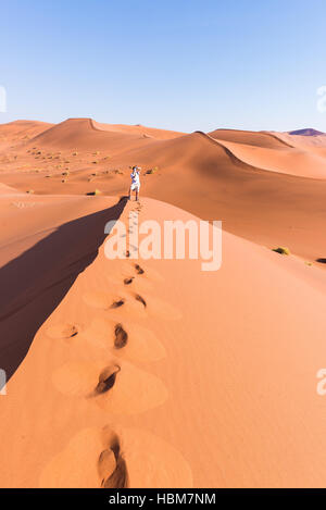 Touristen halten Smartphone und nehmen Foto an malerischen Dünen im Sossusvlei, Namib-Wüste Namib-Naukluft-Nationalpark, Namibia. Abenteuer und ex Stockfoto