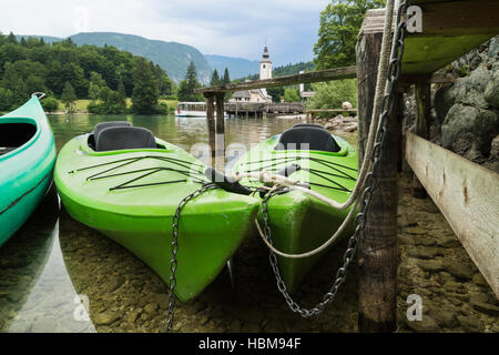 Wocheiner See (Bohinjsko Jezero), Triglav Nationalpark, obere Krain, Slowenien. Kanus mieten. Die Kirche des Hl. Johannes (Cerkev Sv Janeza) bei Ribcev Stockfoto