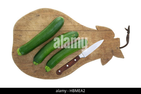 Draufsicht der italienischen Squash auf einem alten Schneidebrett mit einem Messer auf einem weißen Hintergrund isoliert. Stockfoto