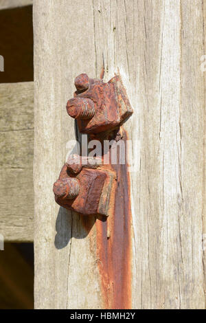 Verrostete Schrauben und Muttern am hölzernen See Wehrmauer Stockfoto