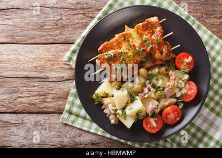 Spanische Pork Kabobs - Pinchos Morunos und einfach Kartoffeln mit Dressing - Patatas Alinadas Nahaufnahme auf einer Platte. Horizontale Ansicht von oben Stockfoto