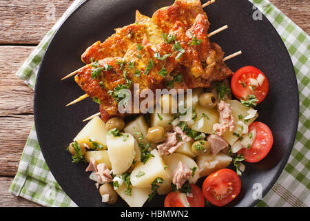 Spanische Kebab Pinchos Morunos und Salat Patatas Alinadas Nahaufnahme auf einer Platte. horizontale Ansicht von oben Stockfoto