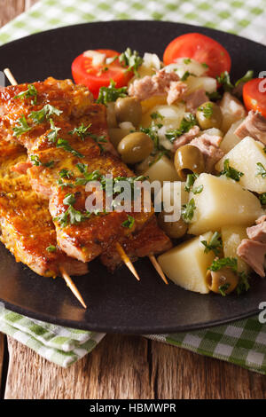 Spanische Kebab Pinchos Morunos-Kartoffel-Salat mit Thunfisch und Kräuter Closeup auf einem Teller. Vertikal Stockfoto