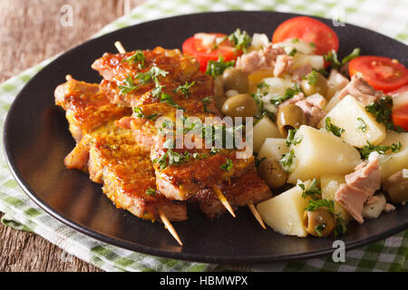 Spanische Spieße Pinchos Morunos und Kartoffel-Salat mit Thunfisch auf der Platte Nahaufnahme. horizontale Stockfoto