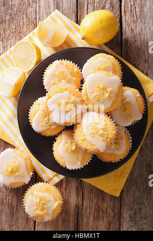 Süße Zitrone Muffins mit Schwung und Vereisung Zucker Nahaufnahme auf einem Teller auf den Tisch.  vertikale Ansicht von oben Stockfoto