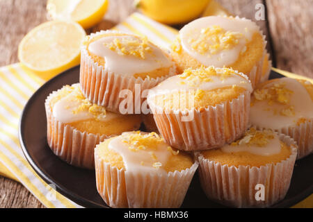 Hausgemachte Zitronen Muffins bestreut mit Lebensfreude hautnah auf einem Teller auf den Tisch. Horizontale Stockfoto