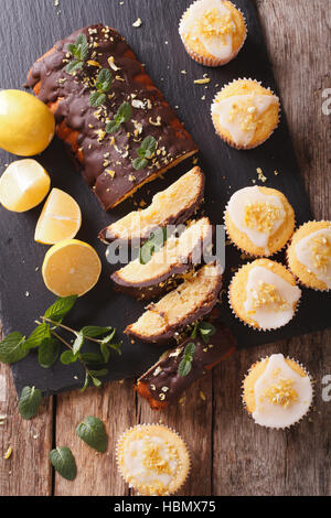 Zitronenkuchen mit Schokolade und Zitrone Muffins mit Zuckerguss Nahaufnahme auf dem Tisch. vertikale Ansicht von oben Stockfoto