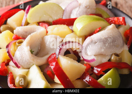 Urlaub Heringssalat mit Kartoffeln, Apfel, Zwiebel, Paprika und Oliven Makro auf einem Teller. horizontale Stockfoto