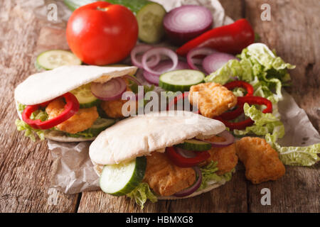 Leckere Pita mit Hähnchen-Nuggets, Gurken, Kohl, Zwiebeln und Paprika Closeup Nappa auf dem Tisch. horizontale Stockfoto