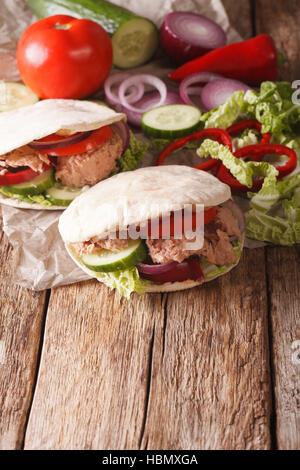 Gesunde Sandwich: Pita mit Thunfisch, Gurke, Nappa Kohl, Zwiebeln, Paprika und Tomaten-close-up auf dem Tisch. vertikale Stockfoto